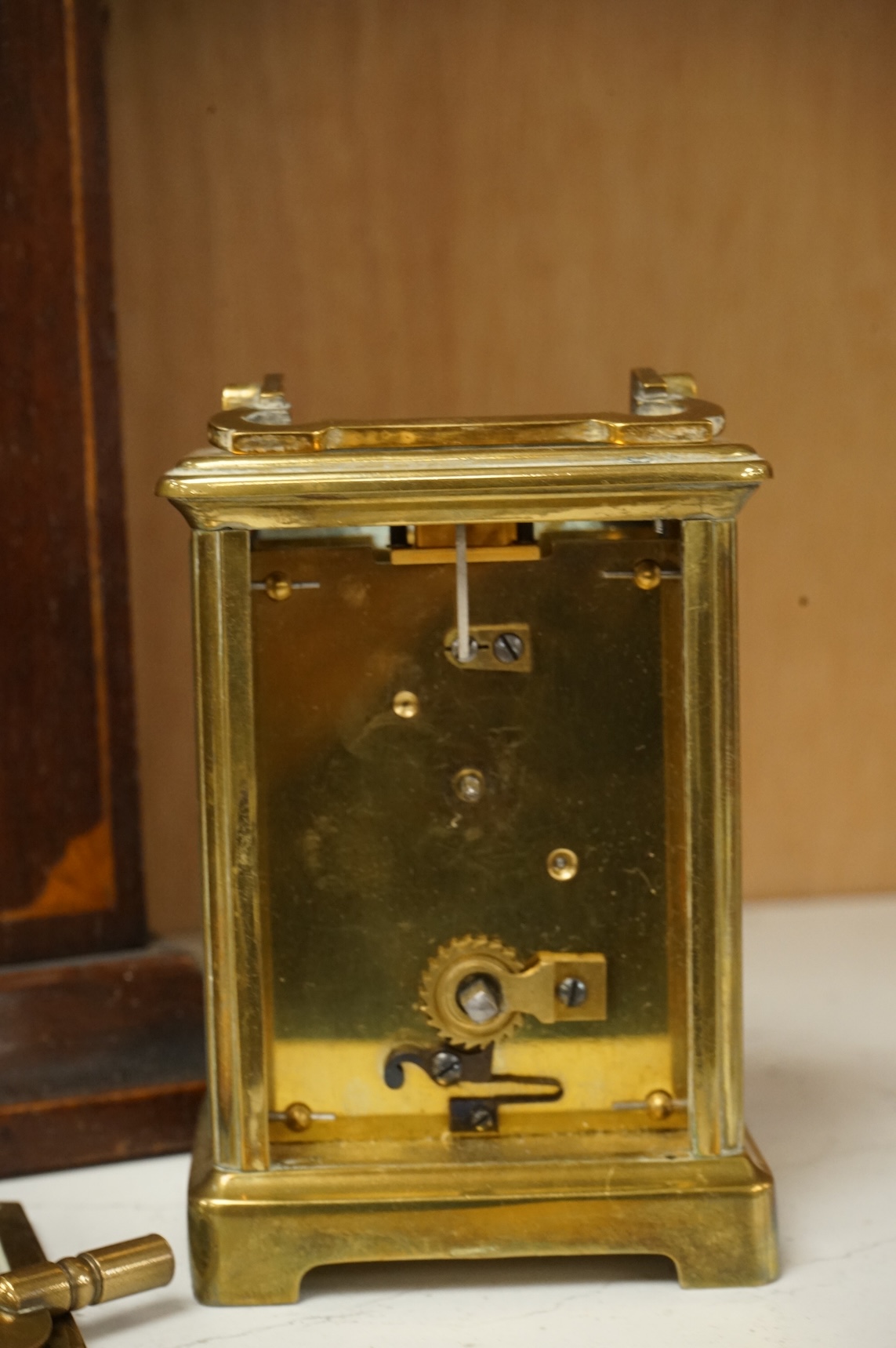 An early 20th century inlaid mantel clock with key and pendulum and a brass cased carriage timepiece, largest 32cm high